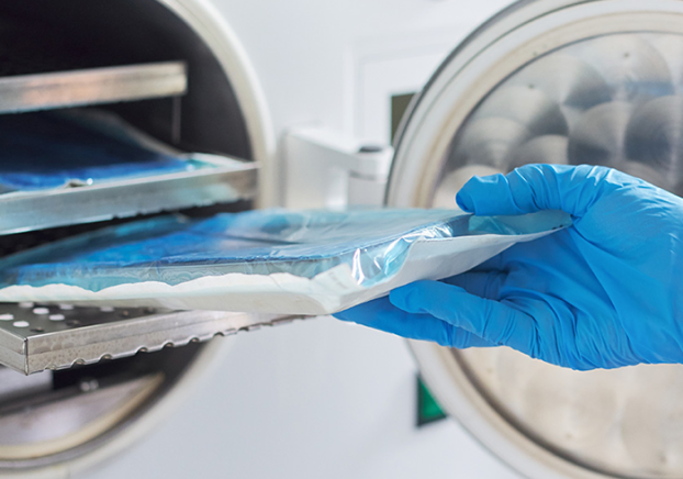 A technician sterilizing medical equipment.