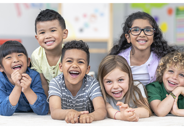 Young children facing the camera and smiling.